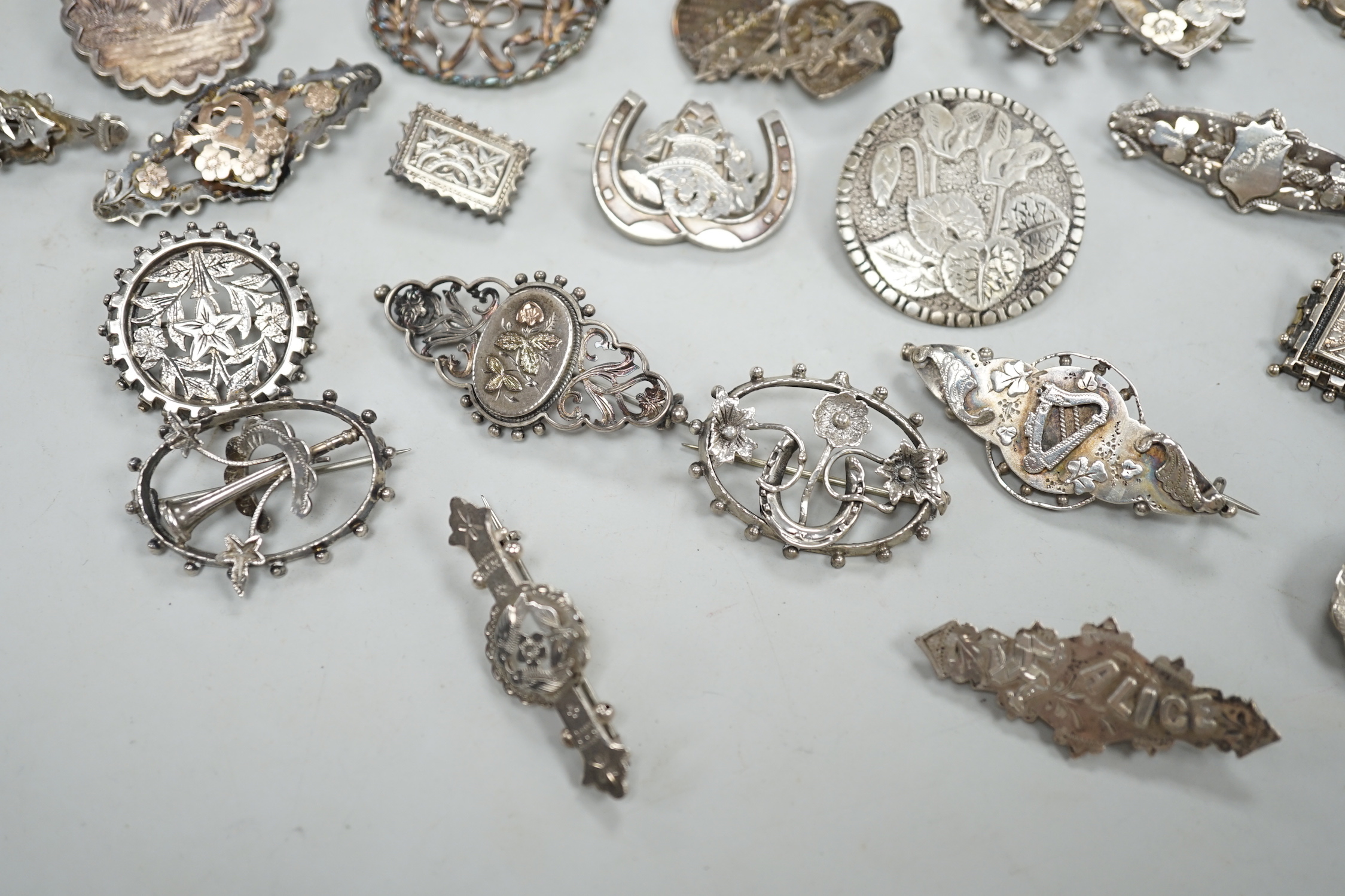 A small collection of twenty nine assorted Victorian and later silver or white metal brooches.